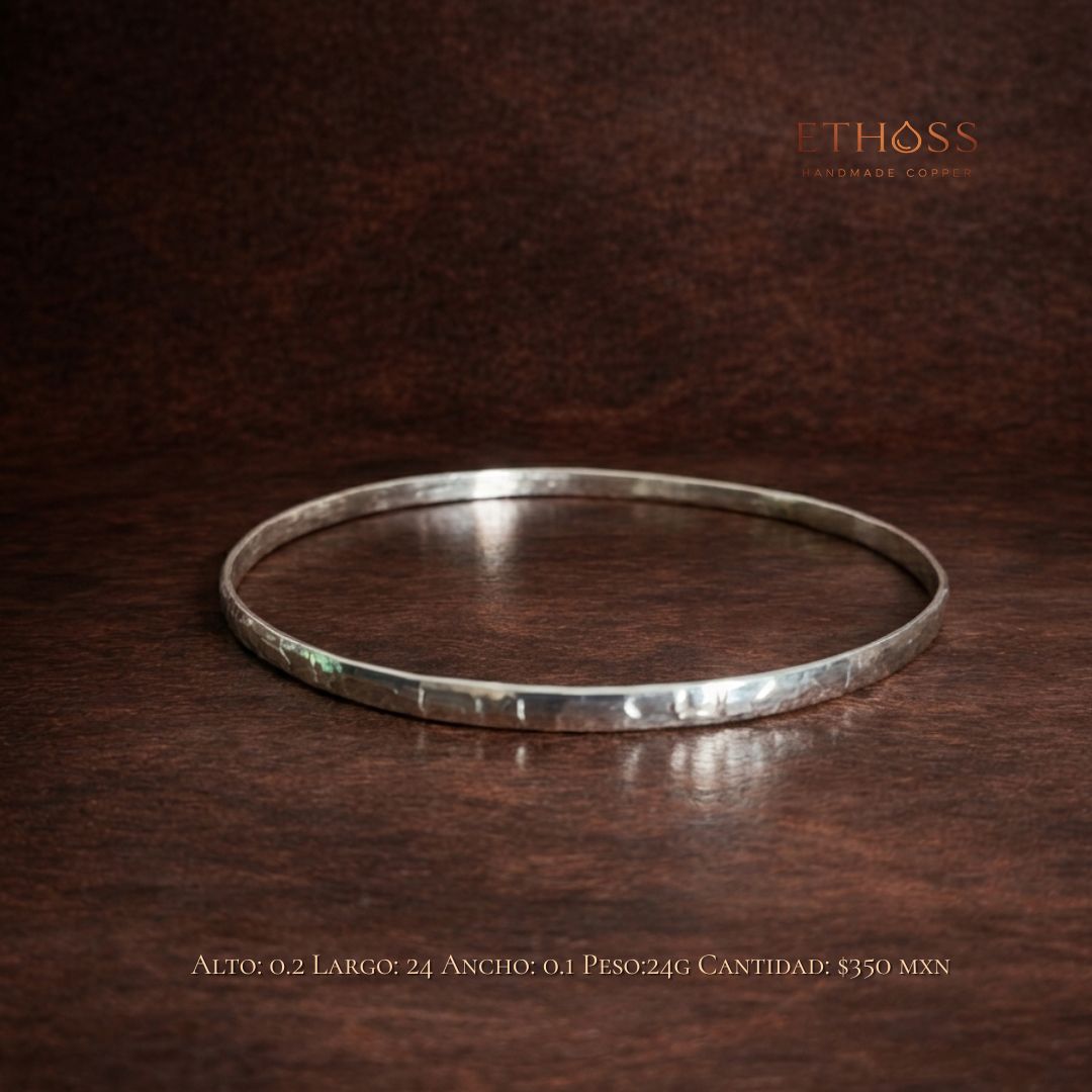 Pulsera fina artesanal en tono plata con diseño minimalista tipo aro, acabado martillado y estilo elegante para uso diario